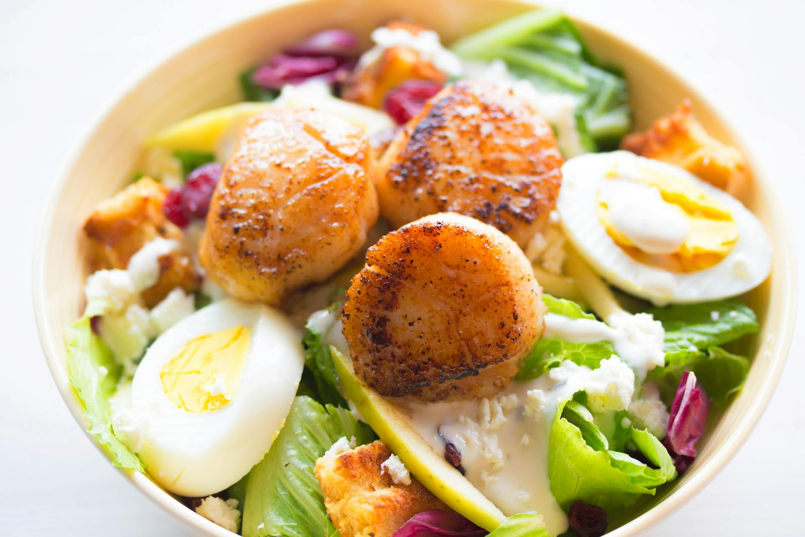 Delicious scallop salad with boiled eggs and fresh greens, perfect for a healthy meal.