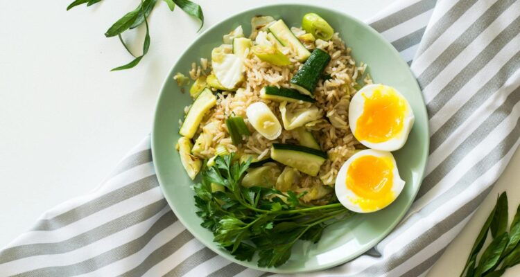 Delicious rice meal with zucchini, greens, and soft-boiled egg, perfect for a healthy diet.